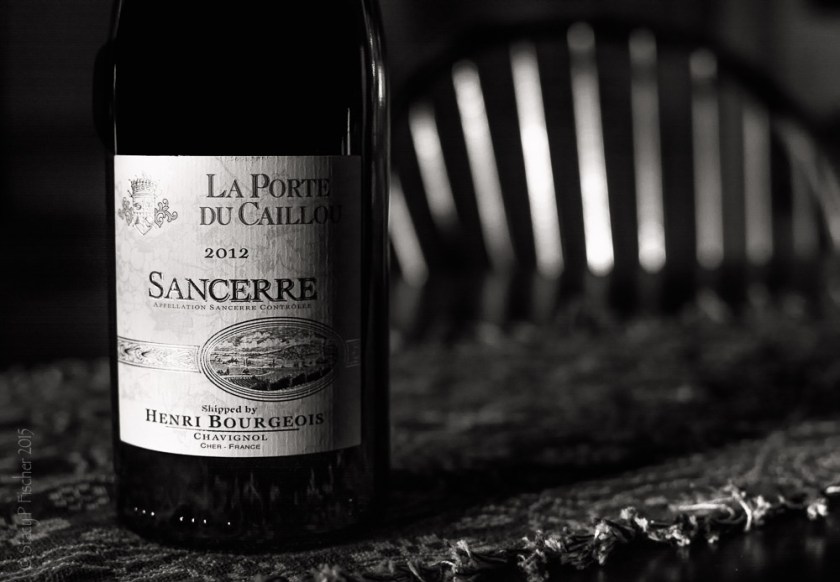 Bottle of Sancerre wine on a table in the shadows of afternoon sun